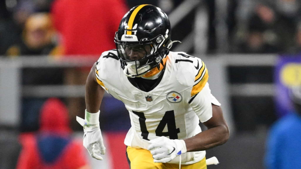 Aggressive football player in Pittsburgh Steelers uniform running on the field during a game.