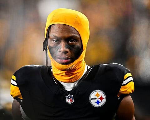 Young African American football player wearing Steelers uniform with yellow head covering and face paint, focusing on game day, NFL athlete, inside the star, Pittsburgh Steelers player, sports photography.
