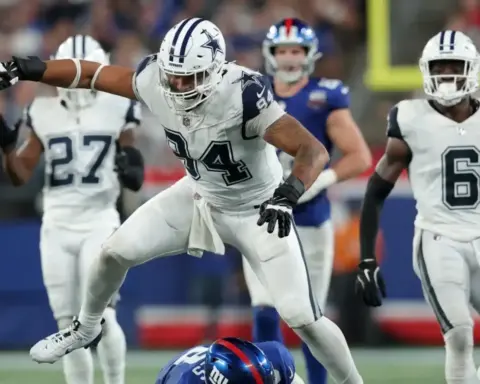 A Dallas Cowboys linebacker tackles a New York Giants player during an NFL game, showcasing football action, team rivalry, and game intensity at the stadium.