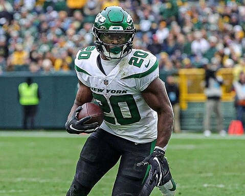 Dynamic image of a football player from the New York Jets running with the ball during an NFL game, showcasing team jersey, helmet, and action on the field, highlighting football and NFL sports content.