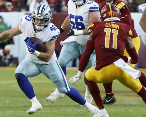 Running back carrying football during NFL game between Dallas Cowboys and Washington Commanders.