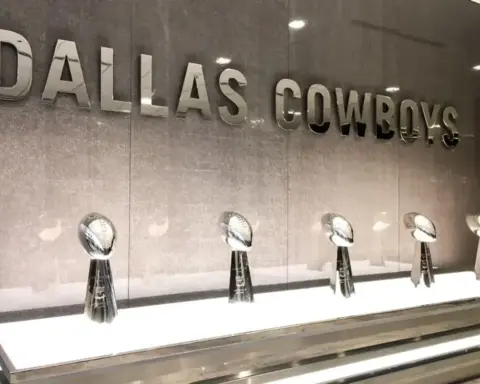 Dallas Cowboys awards display with silver trophies on a white shelf, showcasing the team's achievements and history at Inside The Star.