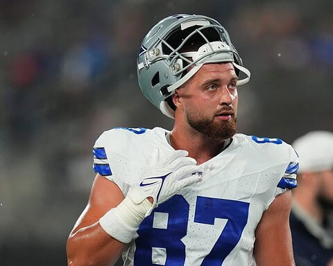 NFL player in uniform with helmet on, representing Dallas Cowboys, on the field during a game or practice, focused and ready.