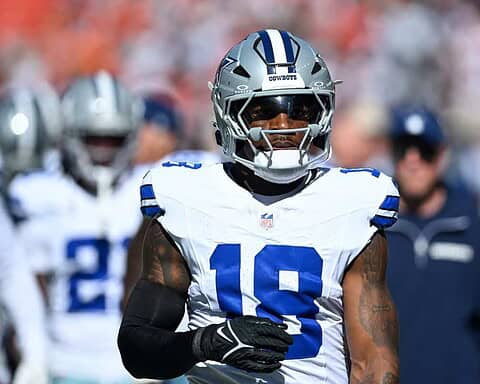 Wide receiver CeeDee Lamb of the Dallas Cowboys on the field during an NFL game, wearing team uniform and helmet, showcasing football action and team gear.