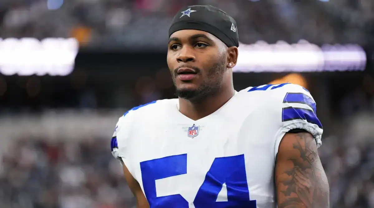 Young African American football player wearing Dallas Cowboys uniform with number 54 on the field during a game.