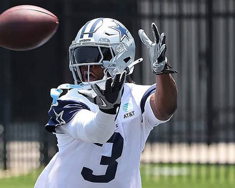 Cornerback in Dallas Cowboys uniform catching football during practice or game.