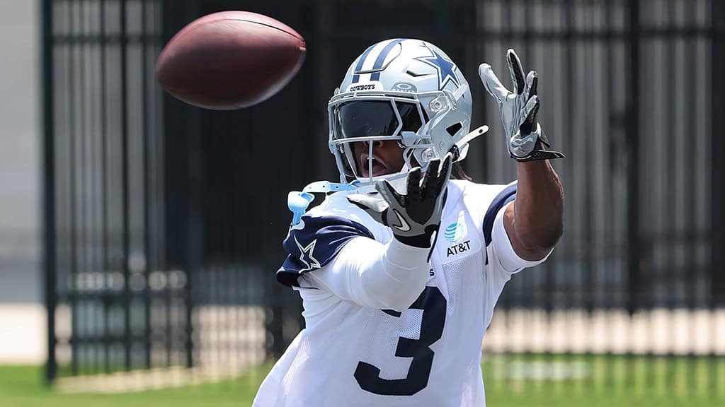 Cornerback in Dallas Cowboys uniform catching football during practice or game.