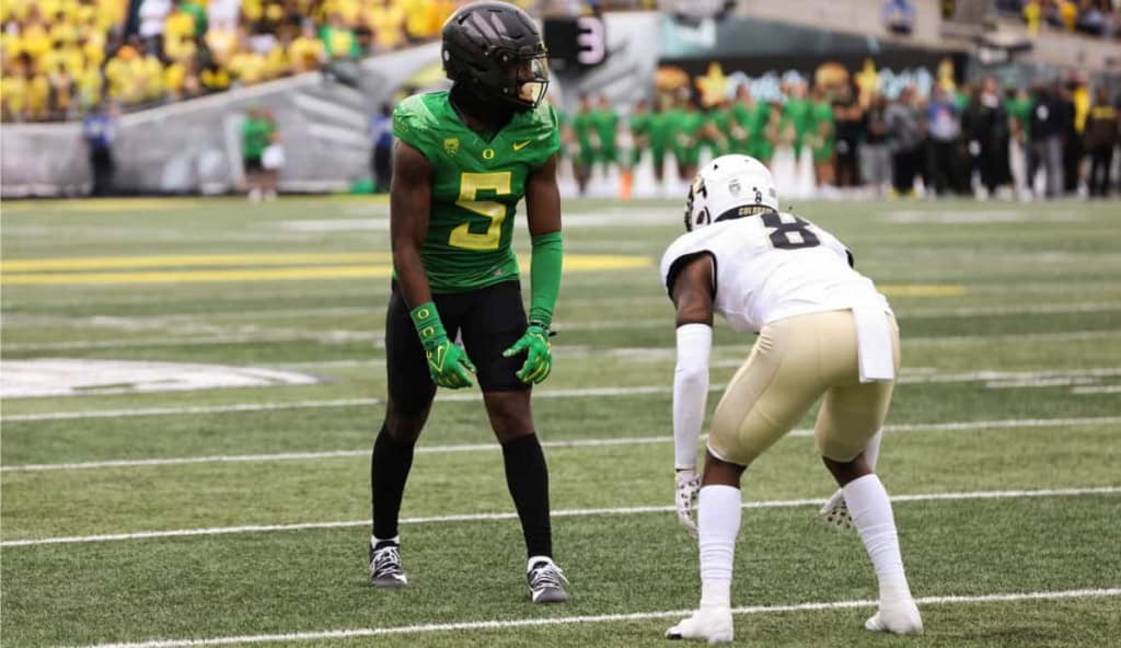 Behind the scenes of college football, players from Oregon Ducks and New Orleans Saints face off on the field during a game, showcasing athleticism and intense competition.