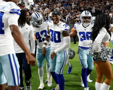 Celebrating Dallas Cowboys football players on the field during a game, showcasing team spirit, camaraderie, and excitement with players in uniforms, including wide receivers and cheerleaders.