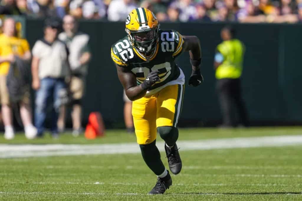 Green Bay Packers football player running on the field during a game, wearing jersey number 22.