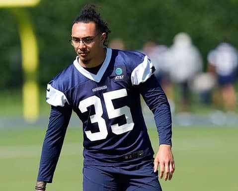 Athletic football player wearing Dallas Cowboys jersey number 35 during practice on a sunny day.