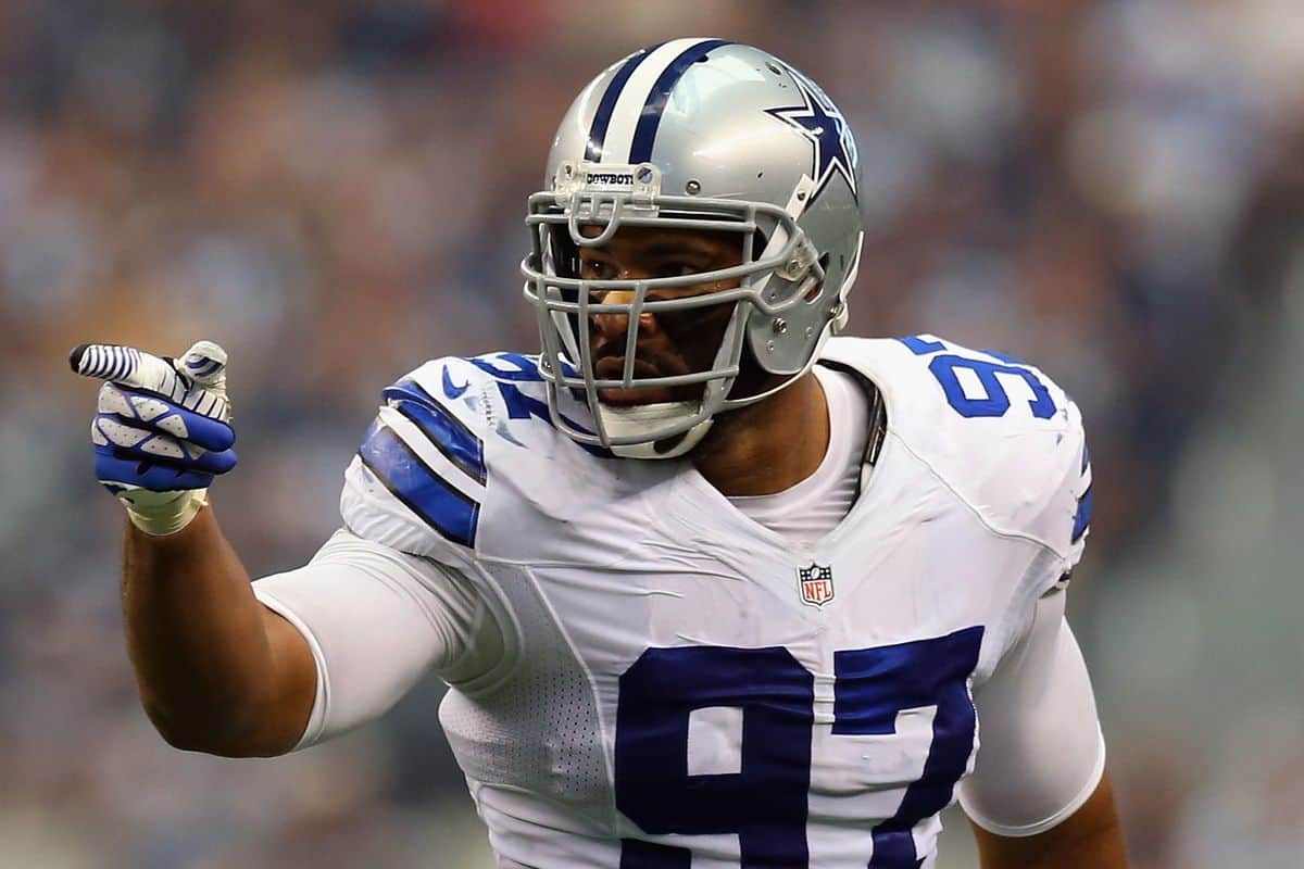 Dallas Cowboys football player in uniform pointing during game action.