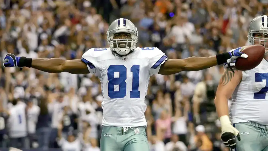 - Wide receiver celebrating with arms outstretched during a Dallas Cowboys football game in the stadium.