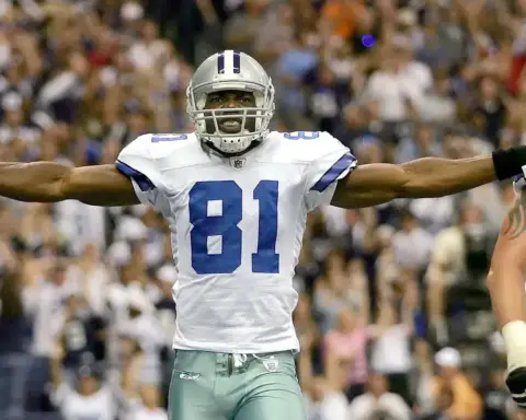 - Wide receiver celebrating with arms outstretched during a Dallas Cowboys football game in the stadium.