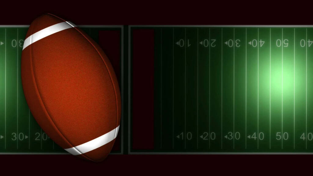 Faded American football resting on a football field with yard lines, illustrating Inside The Star's focus on Dallas Cowboys news and NFL updates.