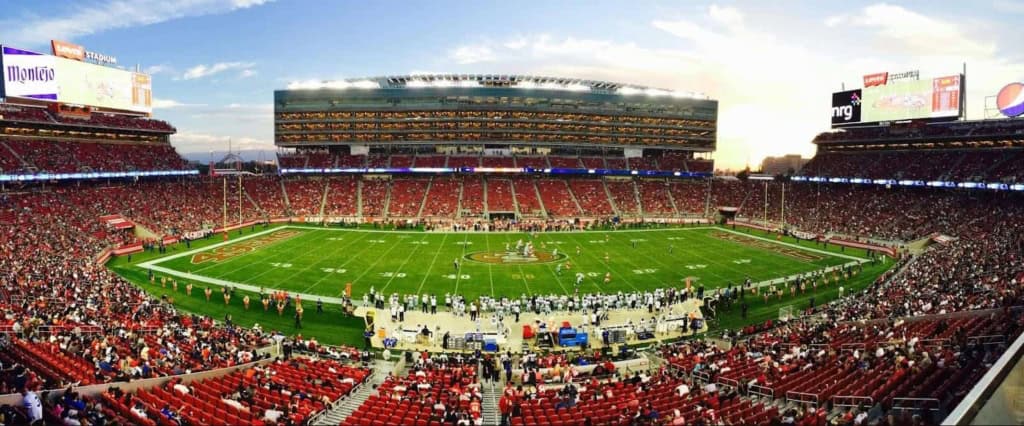NFL football game at Levi's Stadium with enthusiastic crowd and vibrant atmosphere.