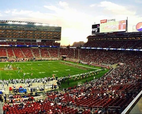 NFL football game at Levi's Stadium with enthusiastic crowd and vibrant atmosphere.