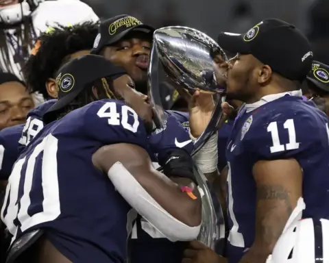 Celebrating Texas Longhorns football victory with team members holding a championship trophy at inside the star.