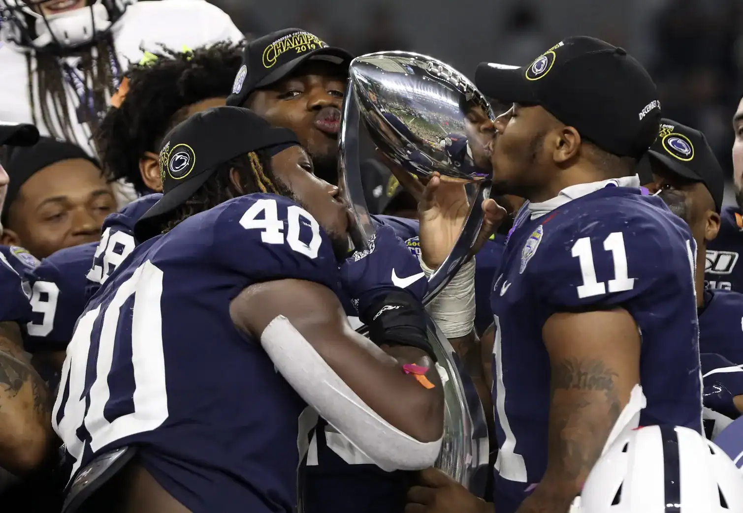 Celebrating Texas Longhorns football victory with team members holding a championship trophy at inside the star.