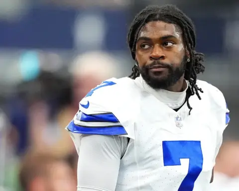 Dallas Cowboys football player on the field during a game, wearing jersey number 2, looking focused and intense, indoor stadium setting.