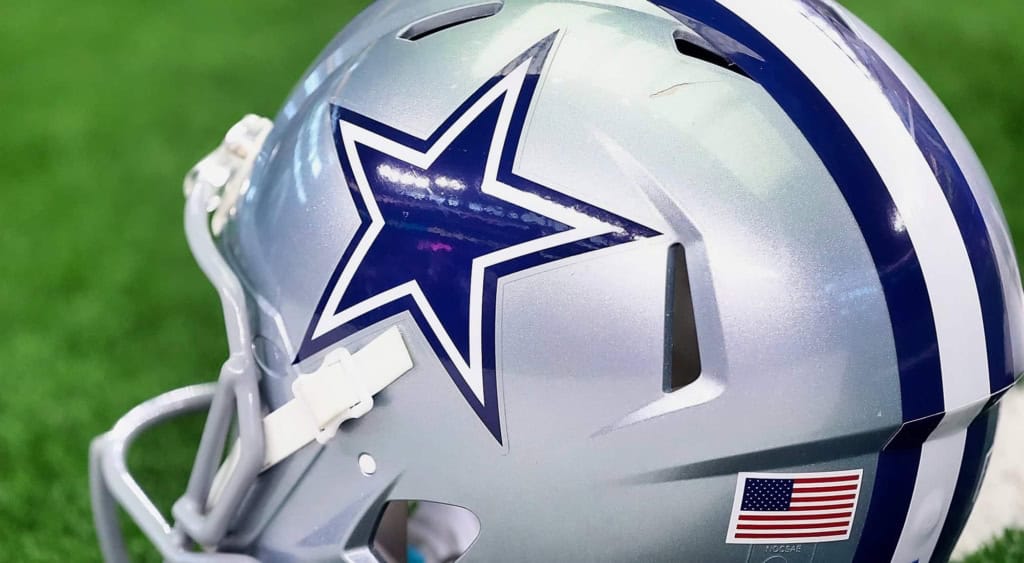 Dallas Cowboys football helmet with star logo on green field, NFL game gear, professional football equipment, American football helmet, sports team apparel, Inside The Star coverage.