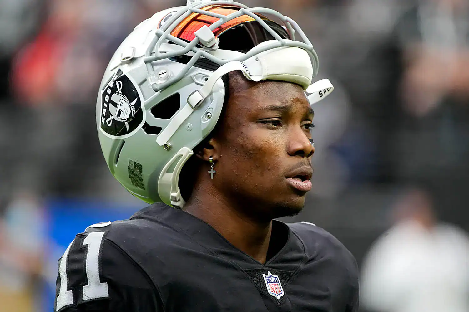 Football helmet worn by Oakland Raiders player on the field, close-up shot during game.