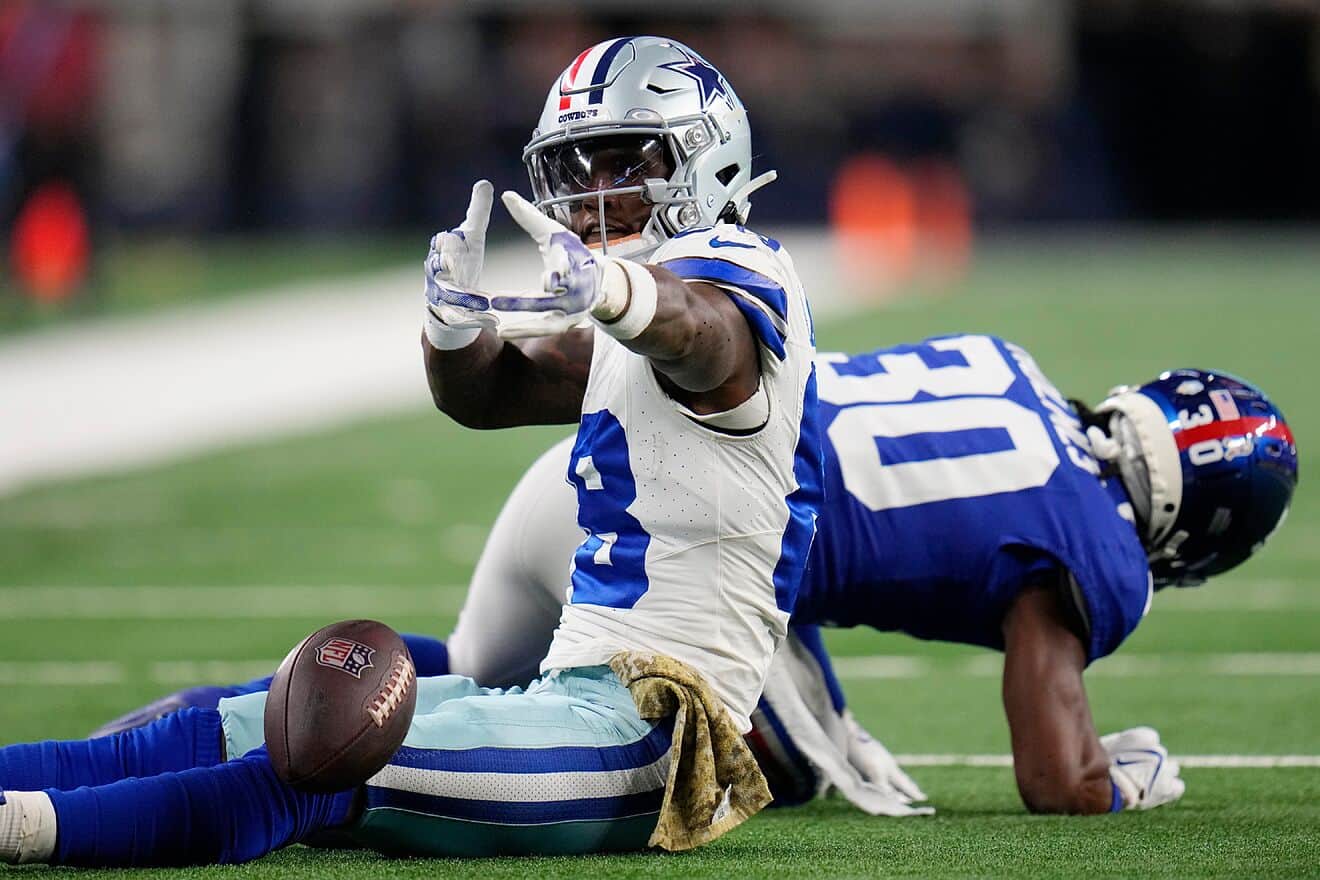 Solid football player making a play on the field during a game; Dallas Cowboys player in action against an opposing team.
