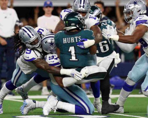Dallas Cowboys defenders tackle a Philadelphia Eagles player during an NFL game. Inside The Star focuses on Cowboys' game analysis, player updates, and team insights for dedicated fans.