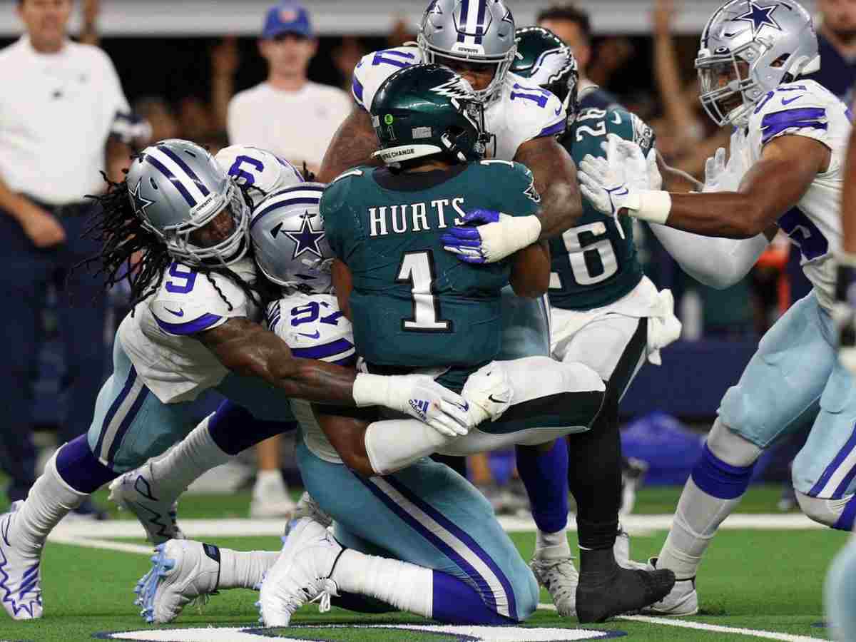 Dallas Cowboys defenders tackle a Philadelphia Eagles player during an NFL game. Inside The Star focuses on Cowboys' game analysis, player updates, and team insights for dedicated fans.