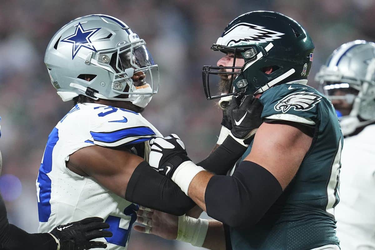 Dallas Cowboys player and Philadelphia Eagles player face off on the football field, showcasing intense rivalry and sportsmanship in an NFL game.