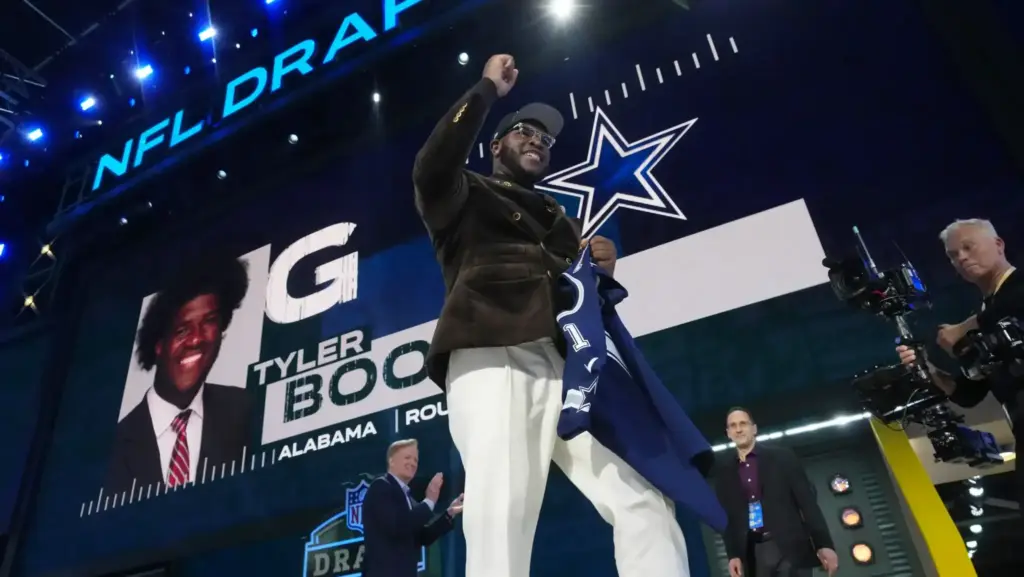 Draft day celebration at the NFL Draft featuring player Tyler Bock posing with franchise logo and fans. The event showcases NFL draft highlights, team selections, and NFL event atmosphere.