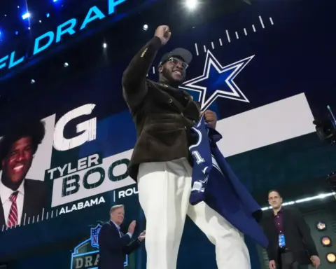 Draft day celebration at the NFL Draft featuring player Tyler Bock posing with franchise logo and fans. The event showcases NFL draft highlights, team selections, and NFL event atmosphere.