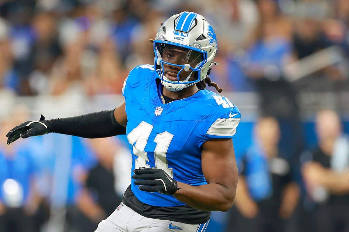 Detroit Lions football player in action during a game, wearing a blue jersey and helmet, focused on the game.