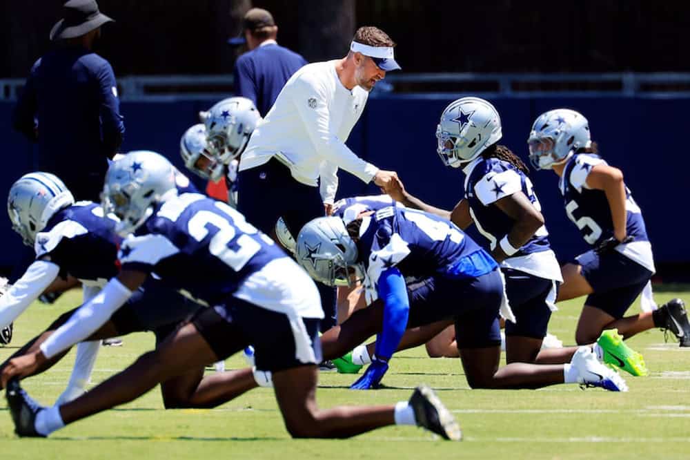 The cowboys are practicing on the field.