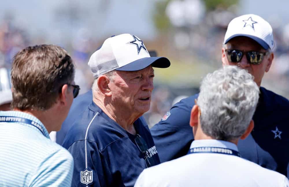 Senior Dallas Cowboys coach talking with team members, NFL game strategy discussion, inside the star, American football fans, Texas stadium, sports team management, Inside The Star image.