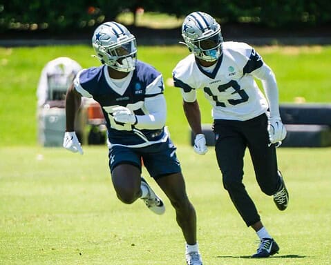 Fast-paced football practice featuring Dallas Cowboys players on a lush green field, emphasizing team training, athleticism, and NFL preparation with players in full uniform and helmets.