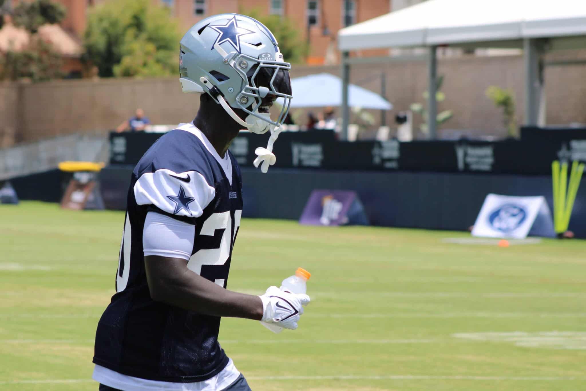Dallas Cowboys football player wearing helmet and jersey during practice at training camp.