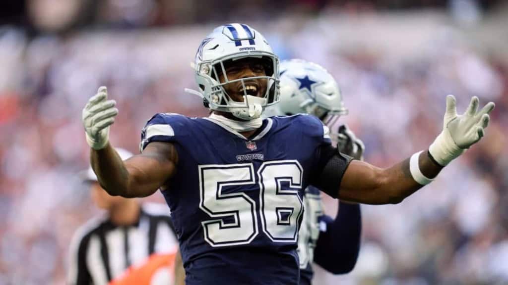 Celebrating a successful play, Dallas Cowboys linebacker in blue jersey with number 56 on the field during an NFL game.