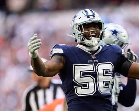 Celebrating a successful play, Dallas Cowboys linebacker in blue jersey with number 56 on the field during an NFL game.