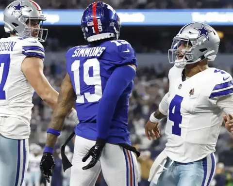 Dallas Cowboys football players on the field celebrating during a game. Wide receiver CeeDee Lamb, quarterback Dak Prescott, and wide receiver Jake Ferguson engaging in team dynamics.