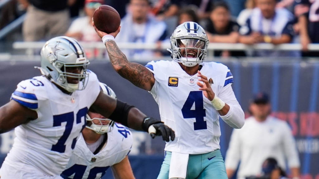 Quarterback Dak Prescott throwing a football during a Dallas Cowboys game, with teammates and fans in the background. Action-packed NFL scene showcasing team leadership and football skills.