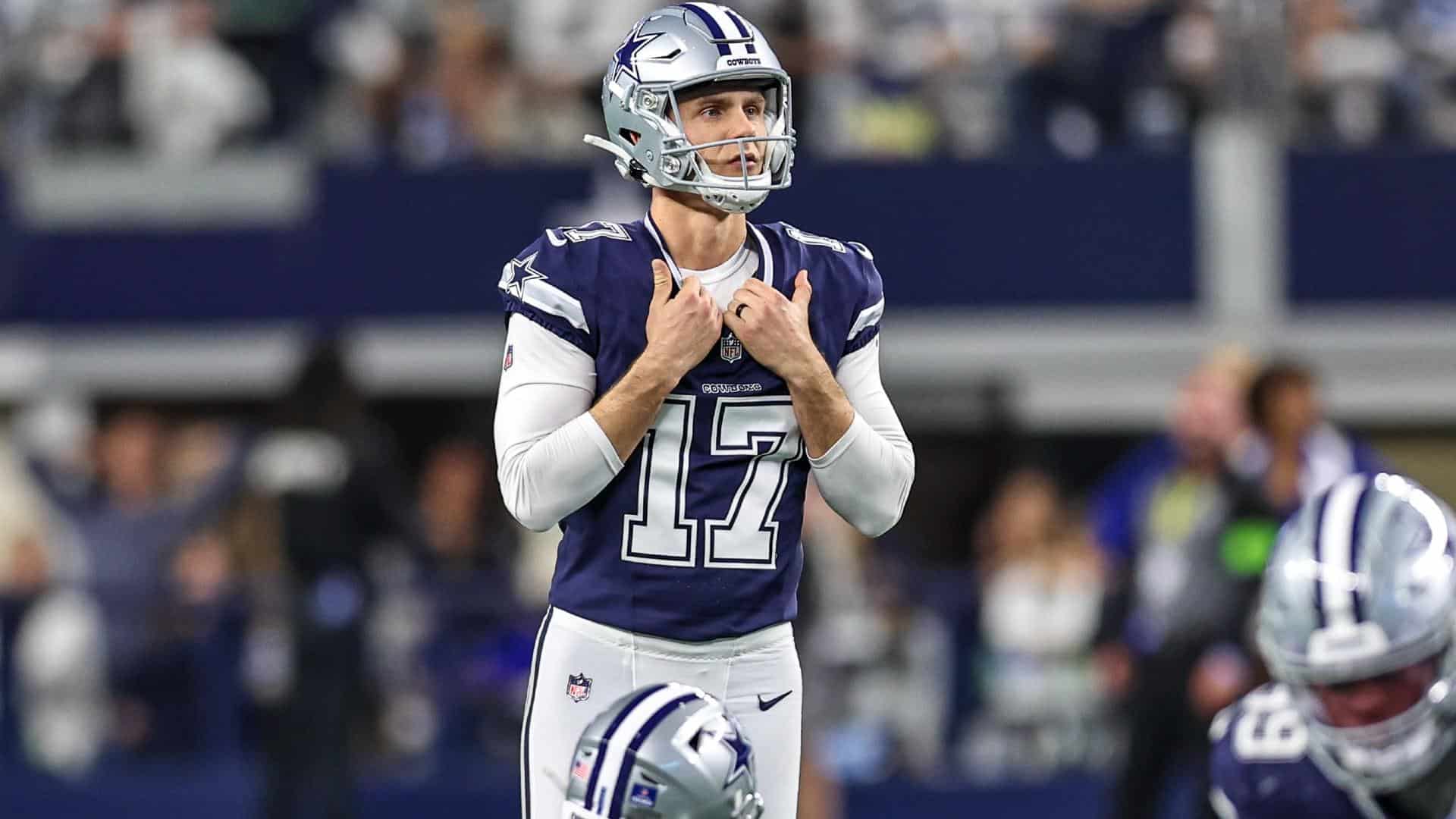 Quarterback Dak Prescott wearing Dallas Cowboys uniform during NFL game, standing on the field with helmet on, focused on the game, showing team spirit and leadership.