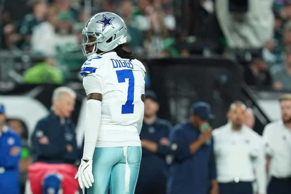 DaqoardDallas Cowboys football player wearing helmet and uniform on sideline during game at AT&T Stadium.
