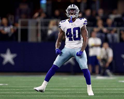Dallas Cowboys football player celebrating on the field during a game, wearing jersey number 40, in a stadium with fans in the background.