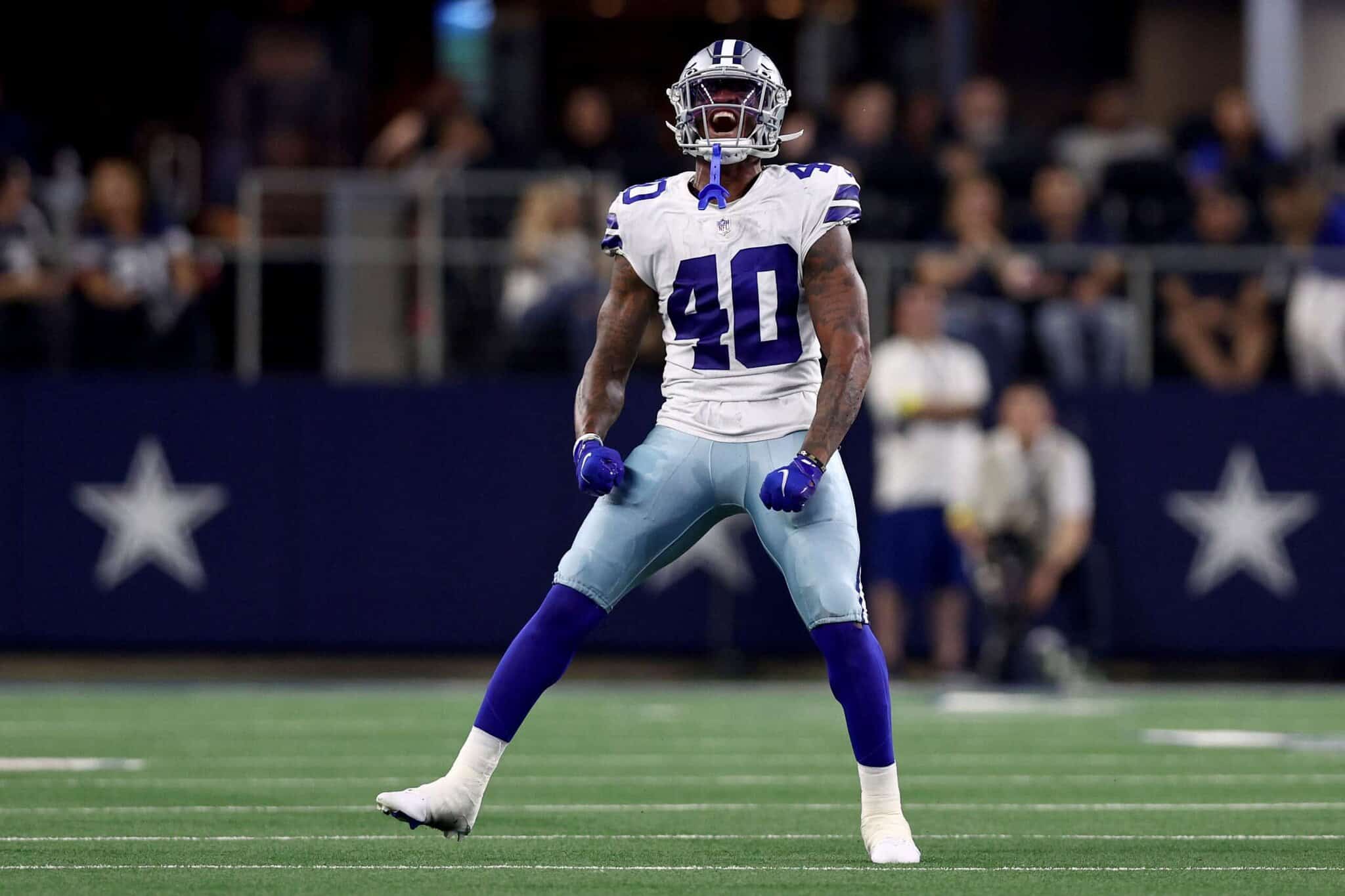 Dallas Cowboys football player celebrating on the field during a game, wearing jersey number 40, in a stadium with fans in the background.