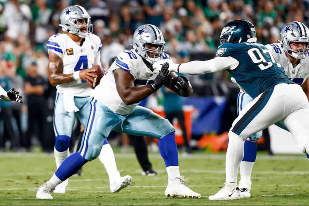 Dallas Cowboys football players in action during a game, showcasing team play, defensive and offensive strategies, and game intensity on the field.