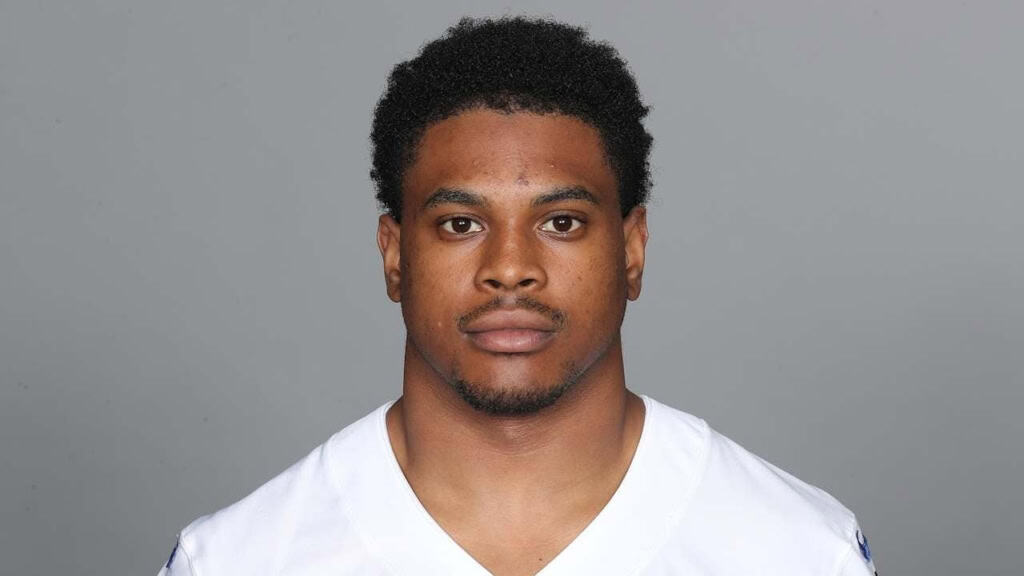 Athletic football player portrait, Dallas Cowboys athlete in white jersey, focused and serious, inside the star sports coverage, NFL team, American football, professional sports photography.
