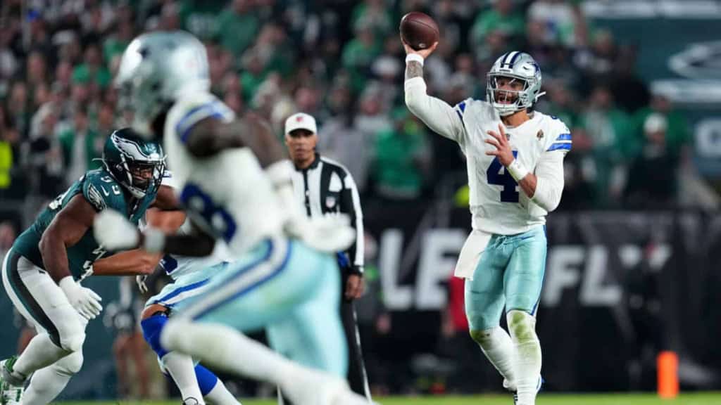 Quarterback Dak Prescott throwing a pass during a Dallas Cowboys game against the Philadelphia Eagles on the football field.