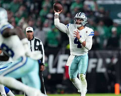 Quarterback Dak Prescott throwing a pass during a Dallas Cowboys game against the Philadelphia Eagles on the football field.