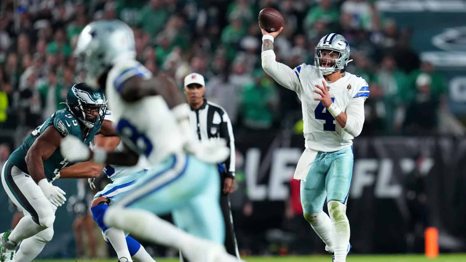 Quarterback Dak Prescott throwing a pass during a Dallas Cowboys game against the Philadelphia Eagles on the football field.